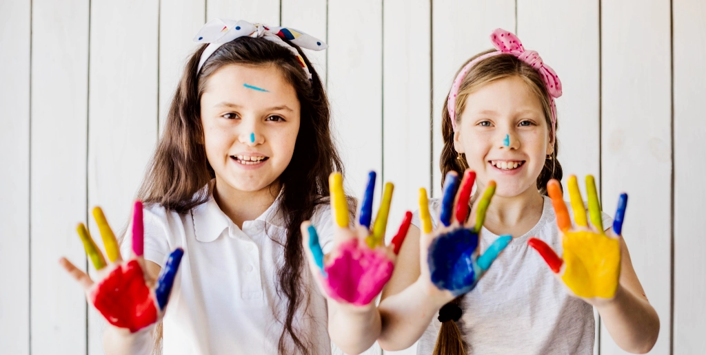 Kinder zeigen bunte Haende in die Kamera