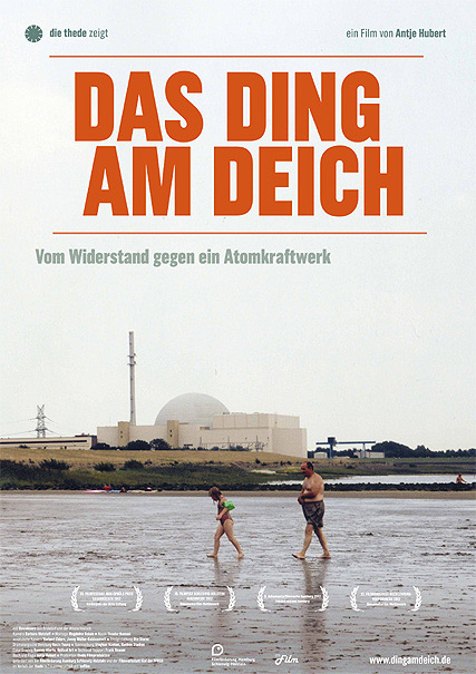 Filmplakat "Das Ding am Deich – Vom Widerstand gegen ein Atomkraftwerk". Das Foto zeigt einen Mann und ein Kind, die in Badekleidung vor der Kulisse des Atomkraftwerks Brokdorf am Elbstrand entlang laufen.