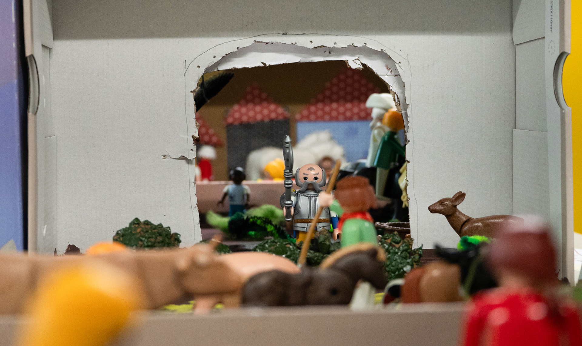 Eine Hand greift in eine Kiste voll mit bunten PLAYMOBIL-Figuren