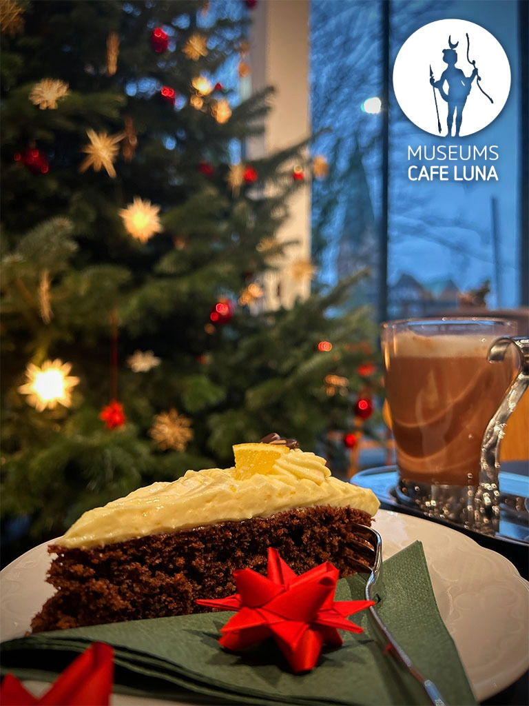 Weihnachtsbaum und weihnachtlicher Gewürzkuchen im Museumscafé Luna, im Hintergrund die St. Johanniskirche.