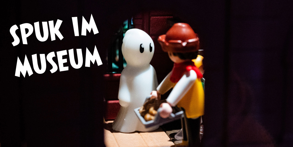 Website MLG Kachel-20-Spuk im Museum Eine Hand greift in einen Berg aus Playmobil-Figuren